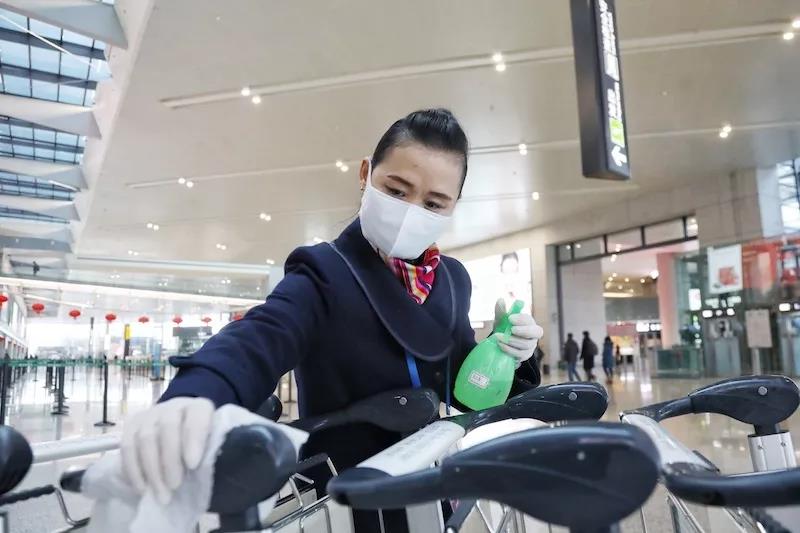 工作人员对手推车进行人工消毒