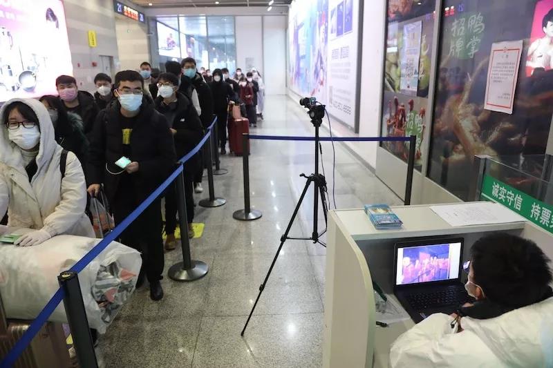 虹桥火车站工作人员对出站的乘客进行红外测温