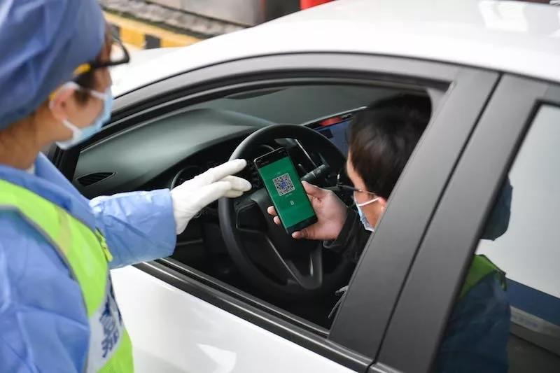 司机向道口志愿者出示二维码