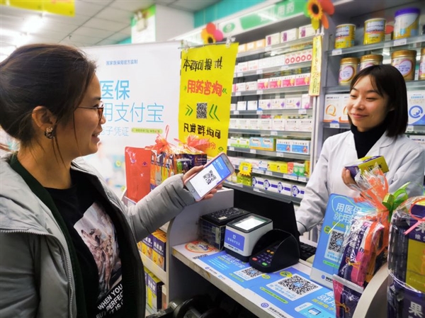 图说：3月14日，一位顾客在济南药店通过医保码扫码支付