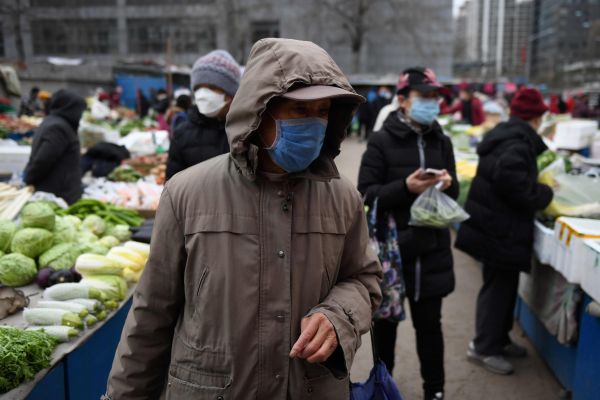 2月27日，北京市民佩戴口罩前往露天菜市场购买蔬菜水果。（法新社）