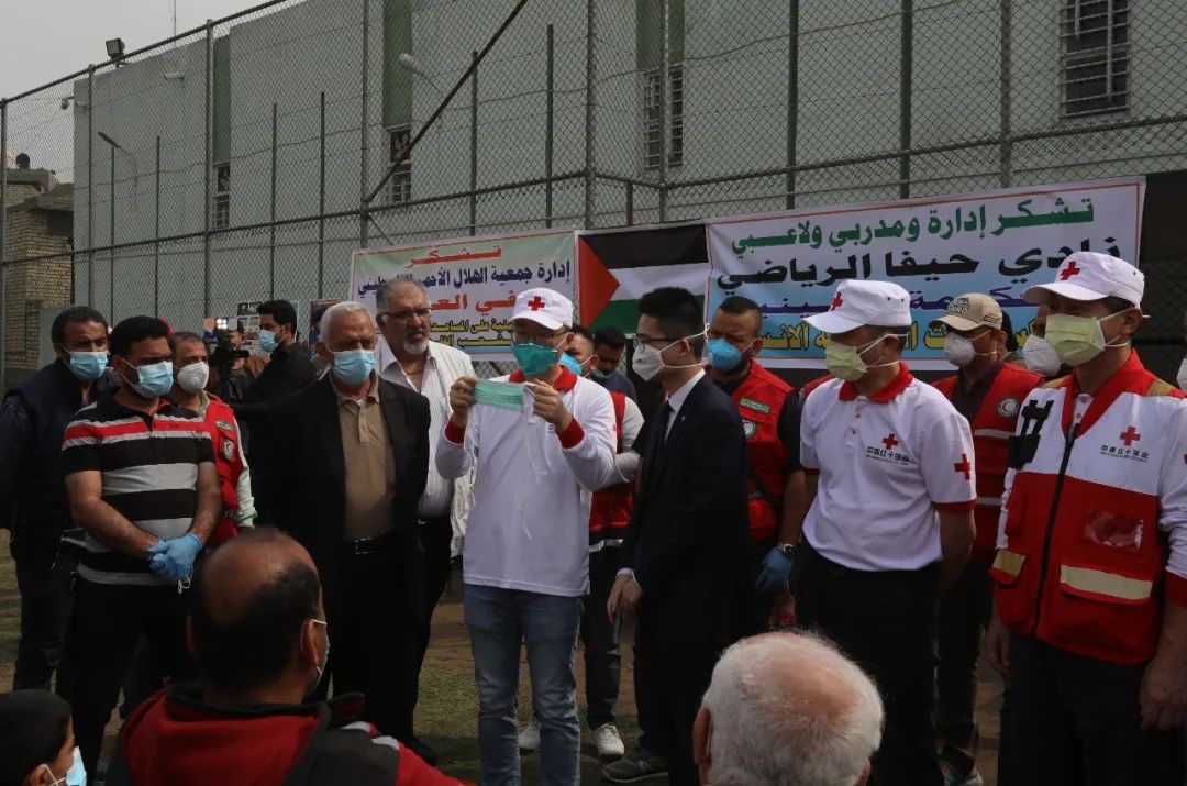 3月16日，在伊拉克巴格达东部的海法巴勒斯坦社区活动中心，中国专家演示口罩佩戴方法。新华社发