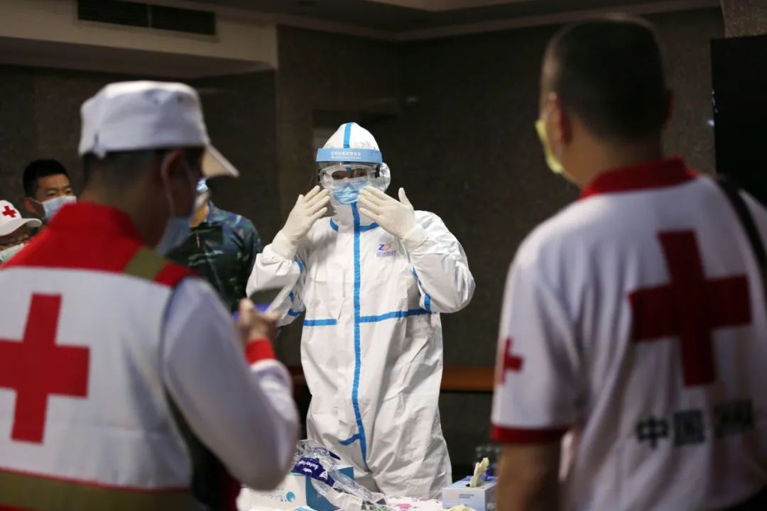 3月10日，在伊拉克巴格达，中国专家组成员徐永昊（中）进行模拟进入疫情污染区防护服穿戴演练。新华社发（哈利勒·达伍德摄）