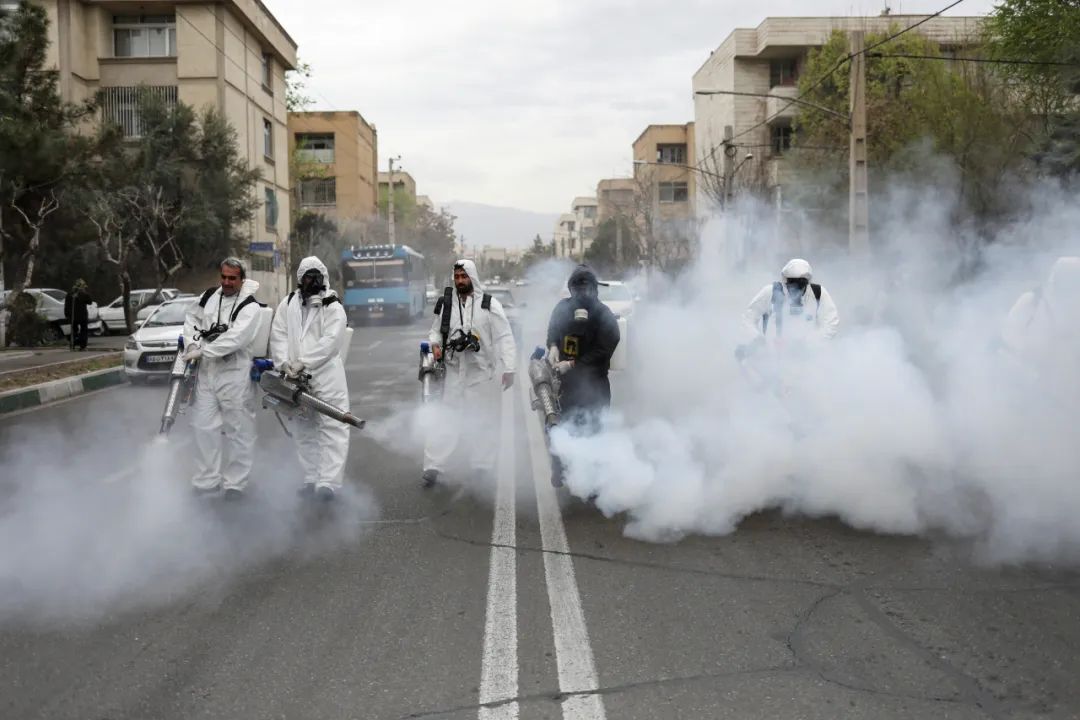3月18日，在伊朗德黑兰，消防员在街道上进行消毒作业。新华社/路透