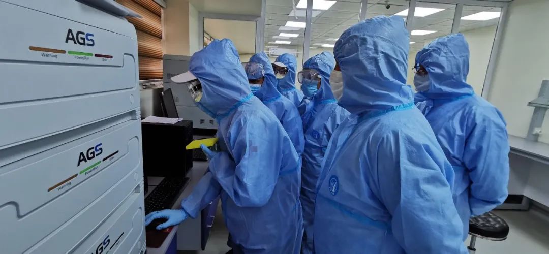 3月18日，在伊拉克巴格达，中国专家组成员调试核酸检测实验室设备。新华社发