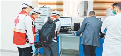 3月18日，由达安基因参与的中国援助伊拉克专家组，正在伊拉克巴格达帮当地医护人员调试核酸检测实验室设备。 　　新华社发