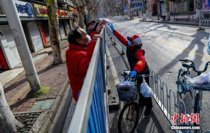 2月29日，武汉江岸区永清街吉林社区志愿者苏仁鹏给居民送药。 中新社记者 张畅 摄