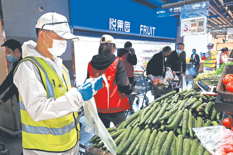 志愿者在超市为居民代购蔬菜 图片来源：长江日报