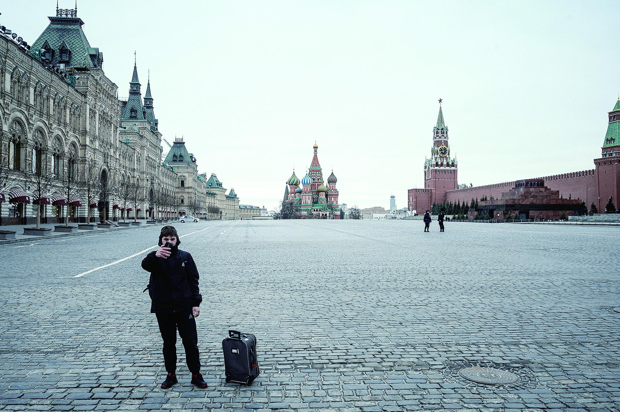 30日，一名游客在空旷的莫斯科红场上拍照。莫斯科要求市民从当天开始待在家中，俄总 统普京呼吁莫斯科民众以严肃和负责任的态度对待这一普遍隔离措施。