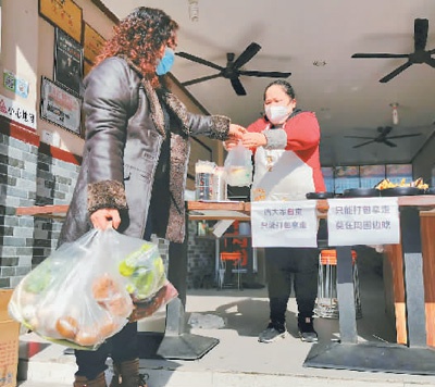 为避免人群聚集就餐,现阶段许多餐饮店只提供打包、外卖业务。图为四川省南充市顺庆区伍家坡一家米粉餐饮店,市民正严格按照疫情防控规定将购买的早餐打包带走。 余中华摄(人民图片)