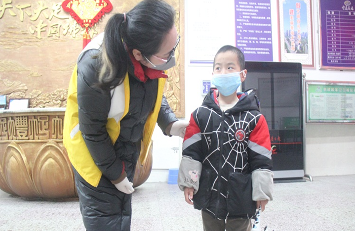 重庆长运集团大足汽车站志愿者张金在售票厅为购票乘客临时照看小孩