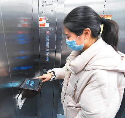  在中国科学技术大学附属第一医院，乘客用“无接触电梯按钮”操作电梯。