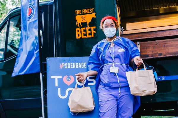 4月15日，在法国巴黎，医护人员来餐车领取免费餐食。新华社发