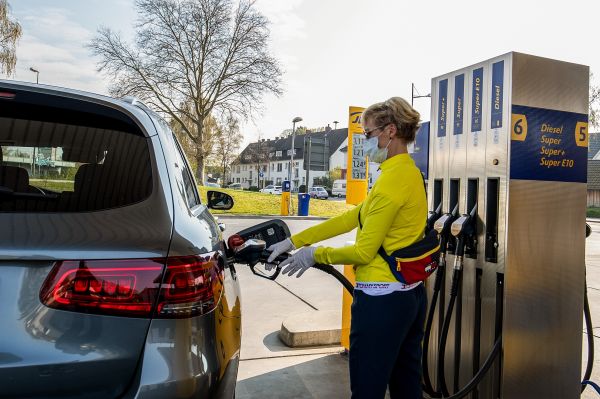 资料图：在德国施韦尔特的一处加油站，一名司乘人员在给车辆加油。（新华社）