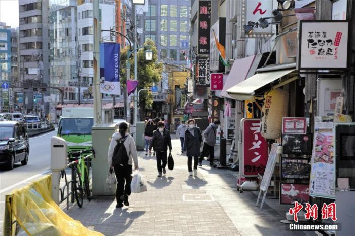 近日，随着日本东京新冠肺炎确诊人数增加，民众减少外出。图为东京戴口罩出行的民众。 中新社记者 吕少威 摄
