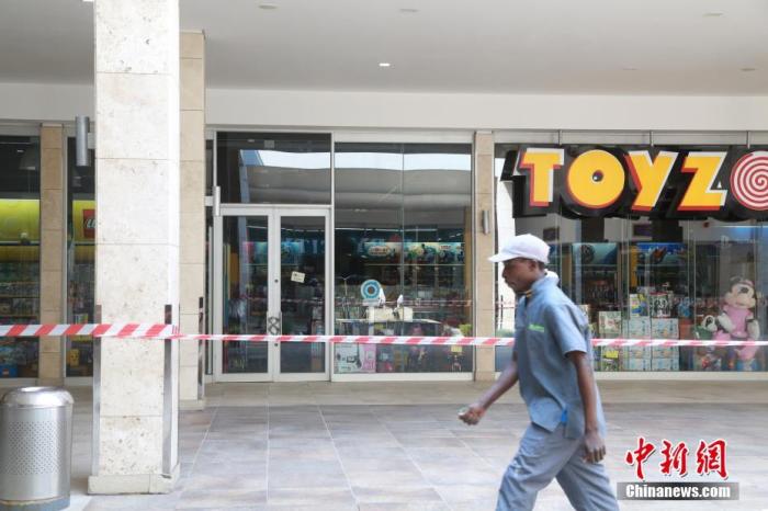 当地时间4日1日，南非约翰内斯堡，关闭的玩具店前已经拉起警戒线，只有个别建筑工人从外面经过。受疫情影响，南非已经实施全国范围“封城”。 中新社记者 王曦 摄