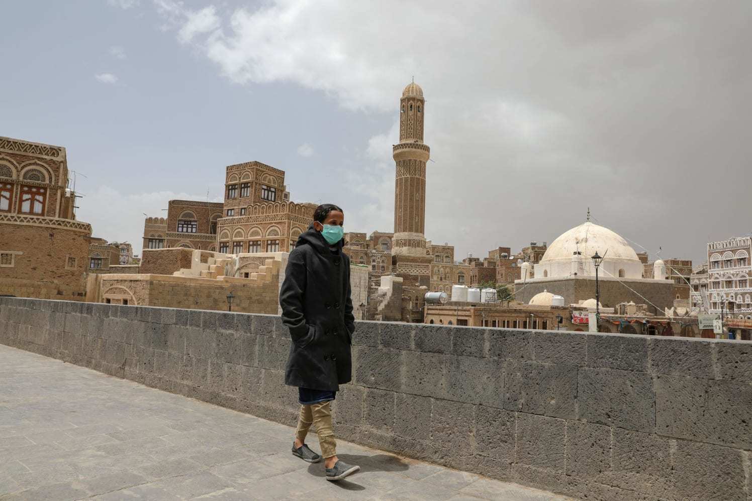 ▲当地时间3月17日，也门首都萨那，戴口罩的女孩走过空荡荡的街头。图据法新社