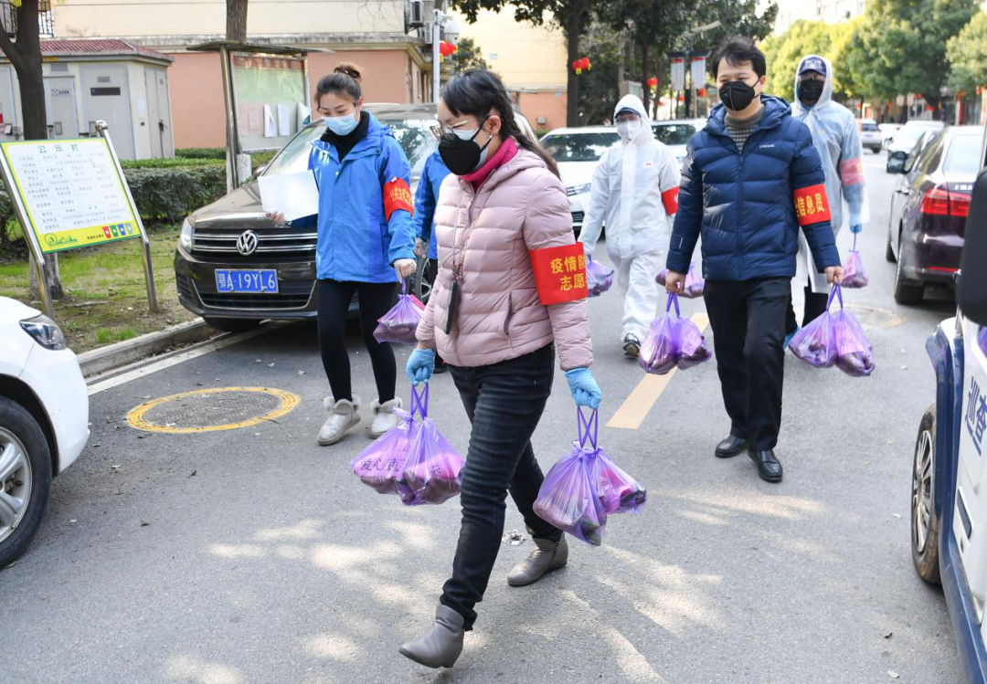 2020年2月23日，武汉市武昌区华锦社区的志愿者为社区居民送菜上门。新华社记者 程敏/摄