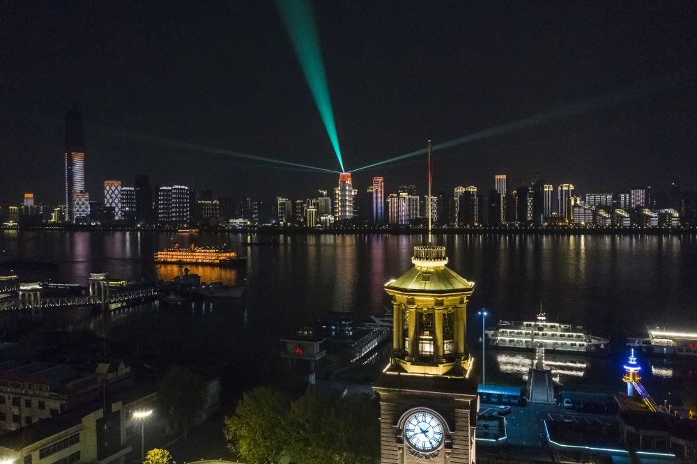 这是4月7日晚拍摄的武汉市江汉关博物馆及长江对岸建筑灯光夜景（无人机拍摄）。4月8日零时起，武汉市正式解除离汉离鄂通道管控措施。新华社记者 沈伯韩 摄