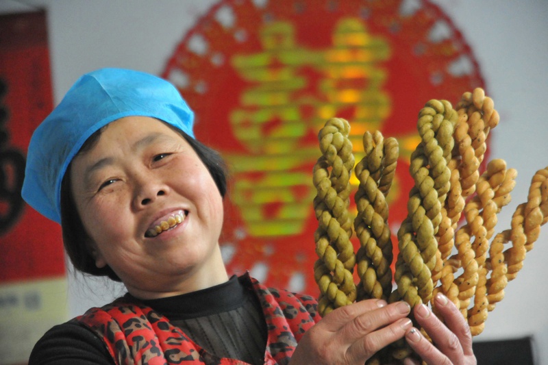 △山西运城市新绛县横桥乡文侯村村民行新枝在展示自己炸制的麻花（2018年12月27日摄）。行新枝在家人朋友的支持下开始创业，制作炸麻花，截至2018年底已带动周边15名留守妇女实现增收。