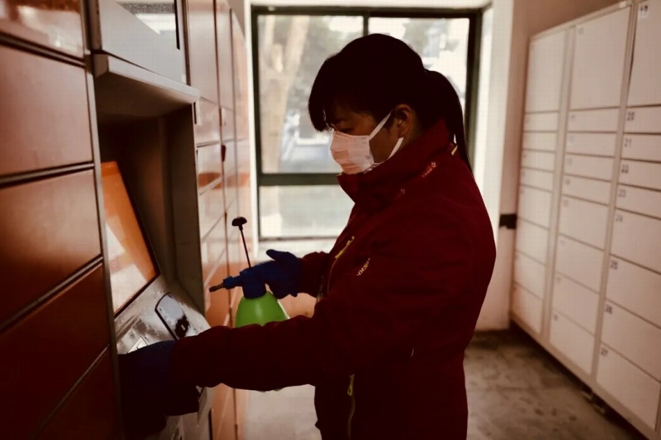 物业工作人员正在给快递柜消毒。