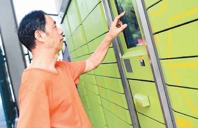 一位居民在社区快递柜收取网购商品。 新华社记者 翁忻旸摄