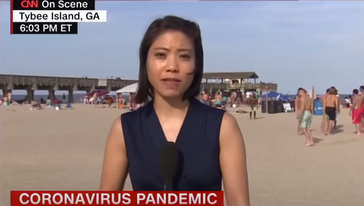 陈亦梵在沙滩采访时，身后游客无人戴口罩（CNN）