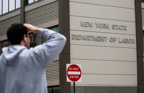 5月8日，在美国纽约，一名行人站在纽约州劳工部大楼附近。新华社发（郭克摄）