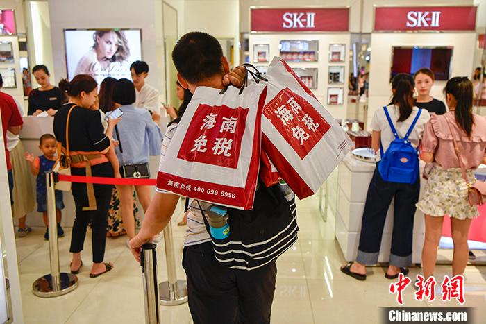 资料图为一位男顾客在海口日月广场免税店内排队买单。 中新社记者 骆云飞 摄