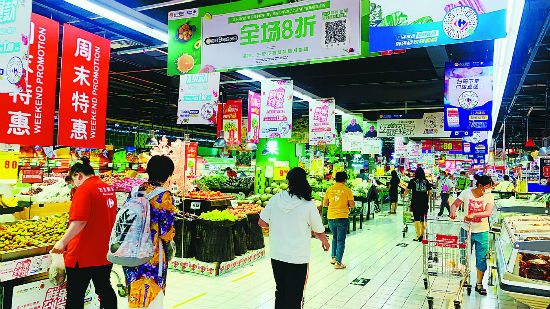 北京家乐福超市门店内，顾客在选购生鲜。企业供图