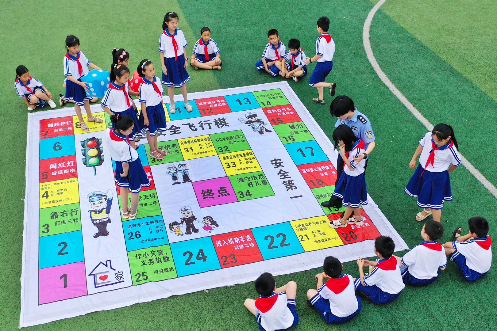 小学的孩子们在县交警大队警察的指导下玩"交通安全快乐飞行棋"游戏