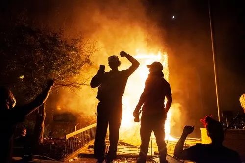  5月28日，在美国明尼苏达州明尼阿波利斯市，示威者在纵火点燃的一警察局附近聚集。新华社发