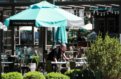 6月22日,在美国纽约布莱恩特公园,一名餐厅工作人员在户外就餐区做准备。新华社记者 王迎 摄