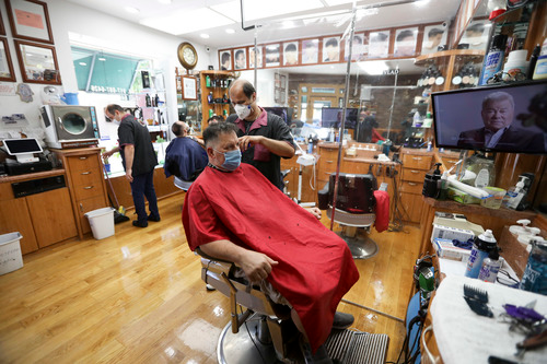 6月22日，顾客在美国纽约一家理发店理发。新华社记者 王迎 摄