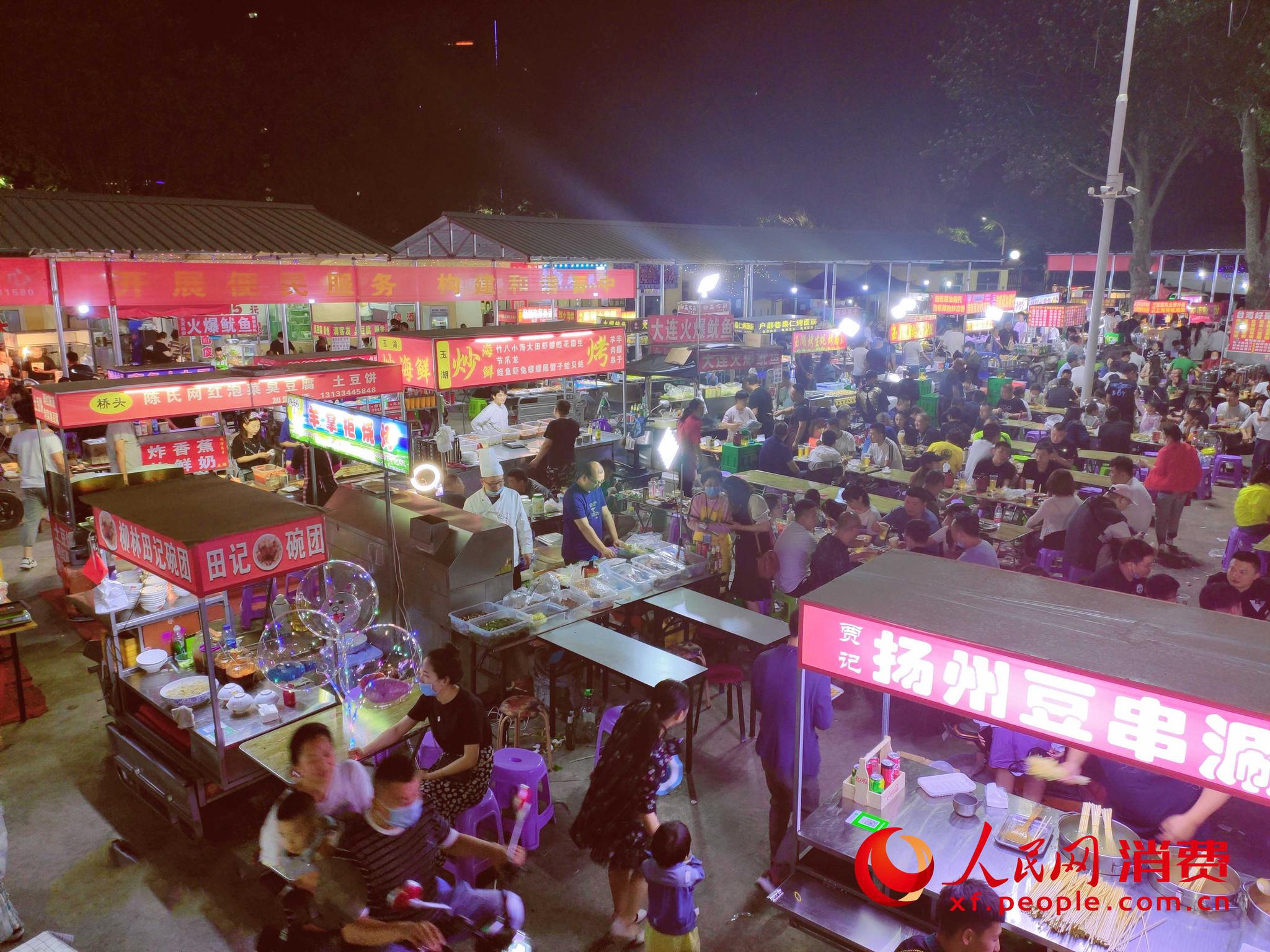 6月19日,人们在山西晋中榆次区桥头美食夜市吃宵夜.