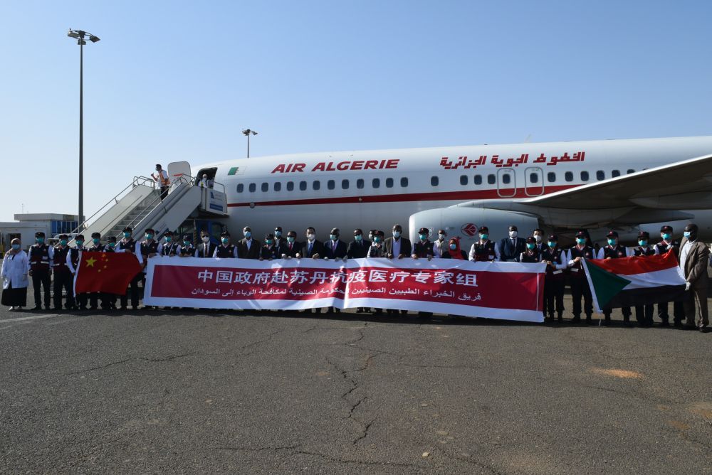 5月28日，在苏丹喀土穆，中国政府抗疫医疗专家组成员与前来迎接的苏丹政府官员等人合影。中国政府抗疫医疗专家组28日下午从阿尔及利亚抵达苏丹首都喀土穆。新华社记者马意翀摄