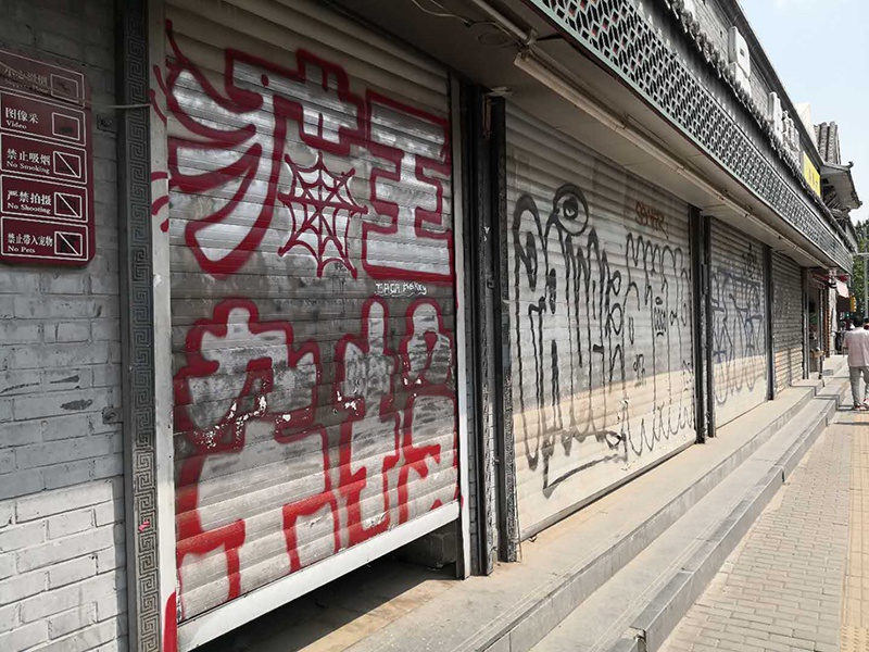 安定门内大街停业店铺大门上的涂鸦. 李凯旋摄
