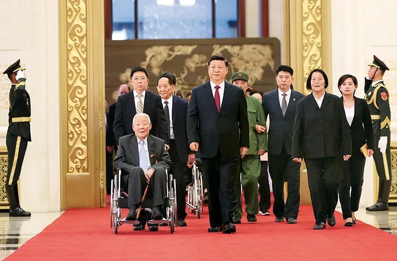 2019年9月29日，中华人民共和国国家勋章和国家荣誉称号颁授仪式在北京人民大会堂举行。这是习近平同国家勋章和国家荣誉称号获得者一同步入会场。