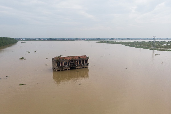 7月11日，在沅江市南洞庭芦苇场澎湖潭垸，一栋房屋被淹（无人机照片）。新华社 图