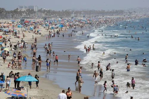  7月12日，人们在美国加利福尼亚州海滨城市圣莫尼卡的海滩上消暑。新华社/美联