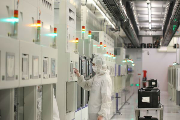  2月18日，在北京经济技术开发区，中芯国际生产厂的工作人员在操作设备。新华社发