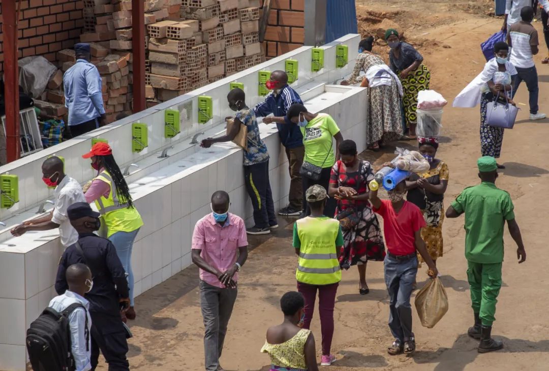 8月7日，乘客在卢旺达首都基加利一处公交站外洗手。新华社发