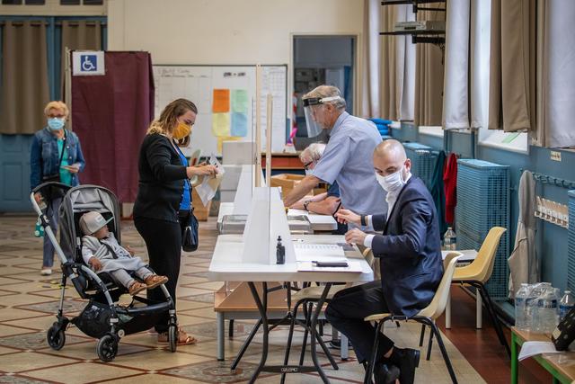 图为法国市民带孩子前往投票现场（图源：新华社）