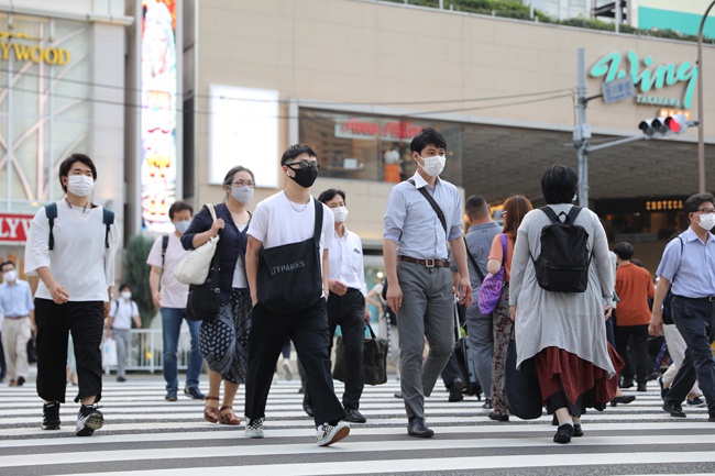 日本单日新增新冠病例数再创新高。图为日本东京，人们戴口罩出行 新华社图