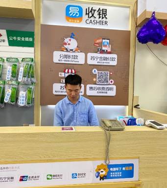 (图：张拓铭在门店收银台)