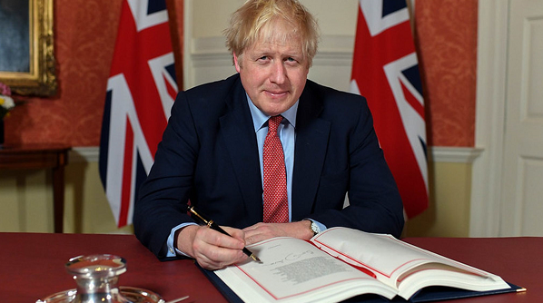 △资料图：英国首相鲍里斯·约翰逊今年1月正式签署英国脱欧协议。图片来自英国天空新闻网