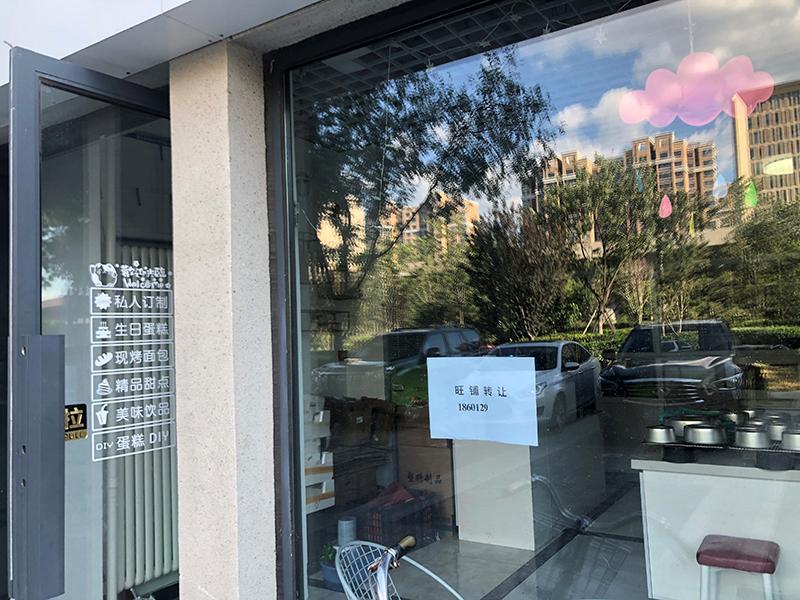 在良乡大学城附近的一条商业街上，一些店铺张贴上了旺铺转让的海报。 陆肖肖摄