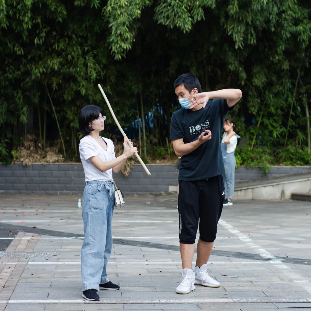 ▲武术协会的成员教一名新生“耍棍” （彭雨格 摄 ）