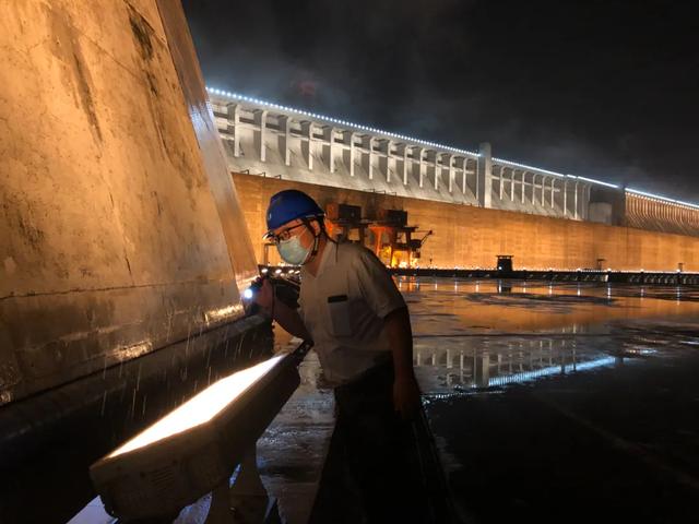 　　▲ 汛期内，长江电力三峡电厂巡检人员在夜雨中检查。