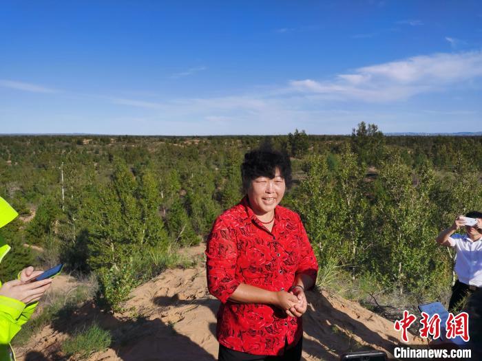 图为53岁的全国劳动模范殷玉珍正在向记者介绍治沙经验&nbsp; 党田野